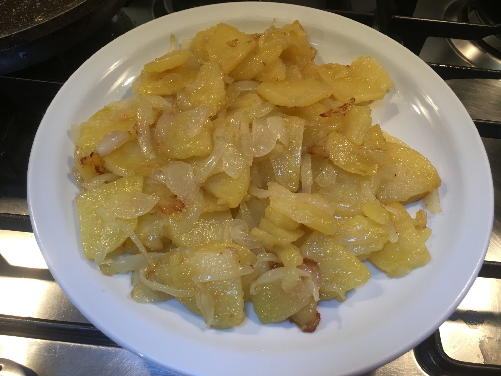 Tortilla di patate al basilico - patate e cipolle a raffreddare su un piatto