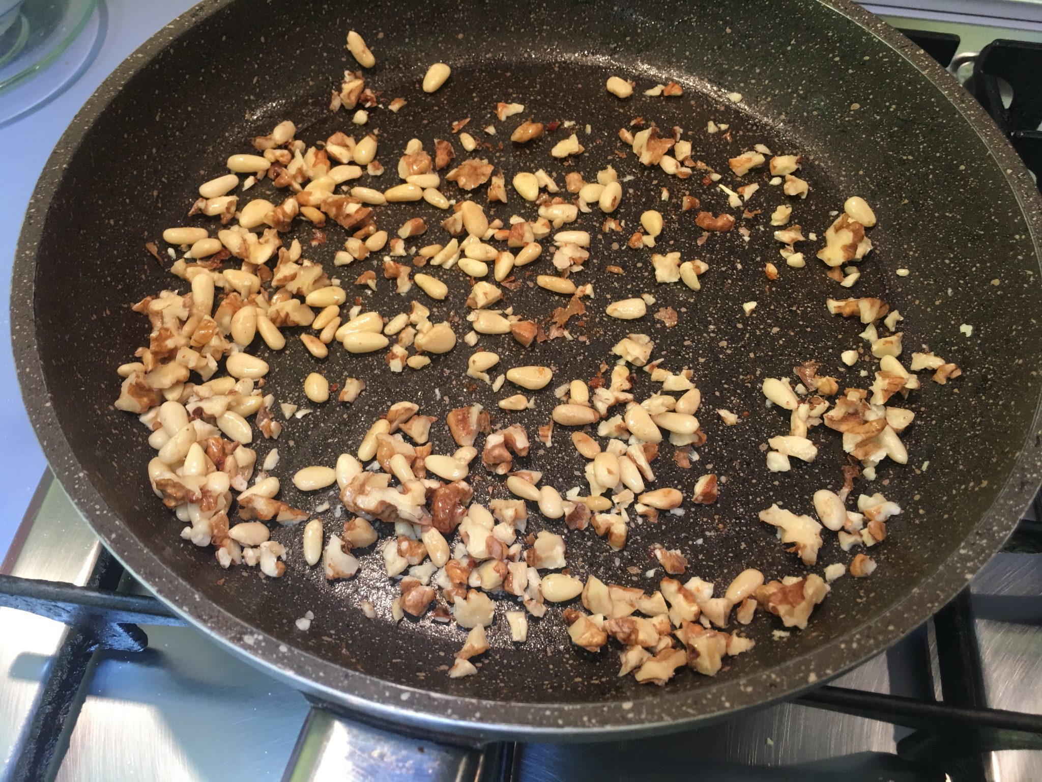 Insalata di valeriana noci e miele - le noci e i pinoli a tostare nel grasso del bacon
