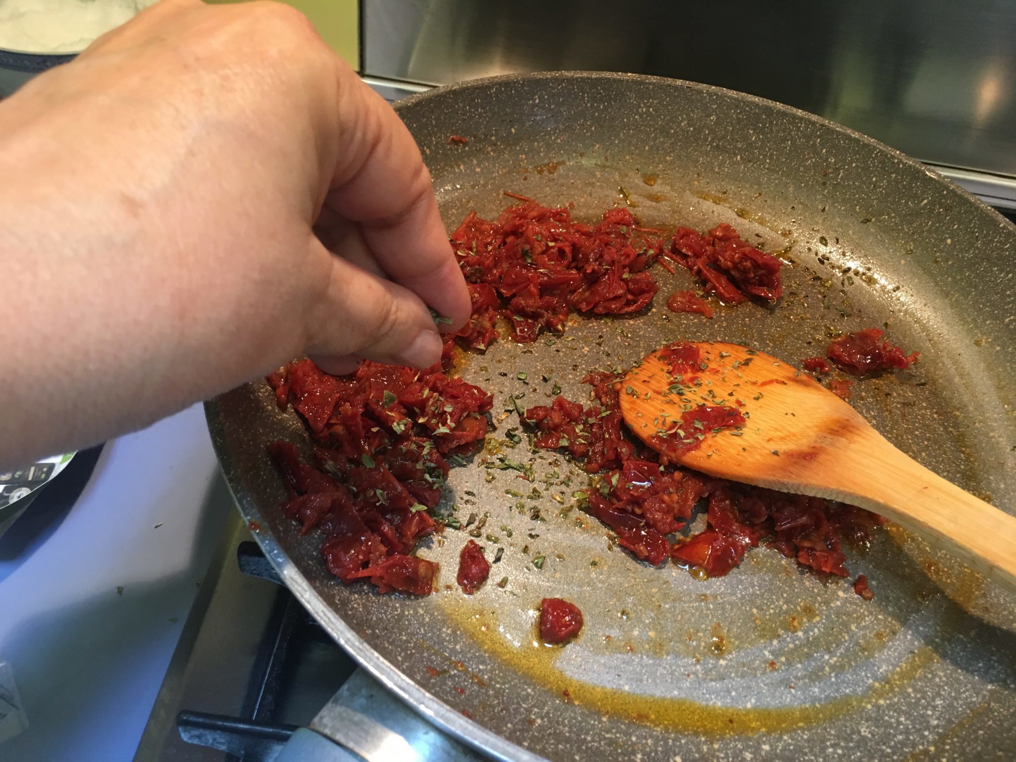 Spaghetti con pomodorini secchi e mollica - aggiunta di origano ai pomodorini in padella