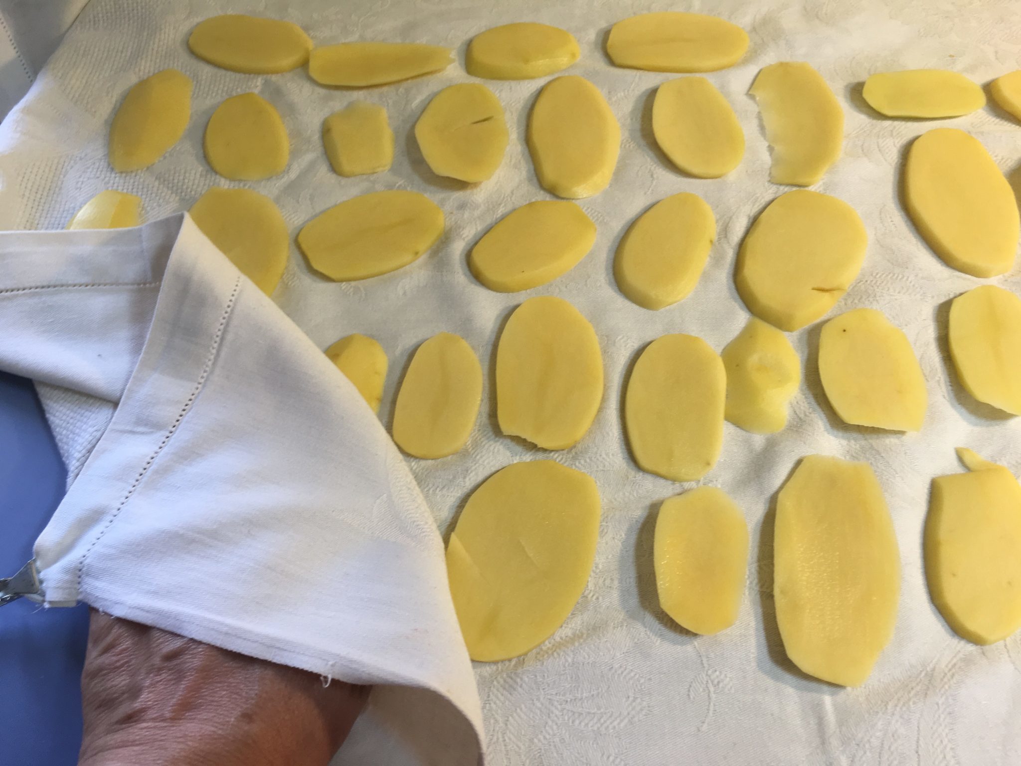 Patate alla parmigiana - patate ad asciugare su panno bianco