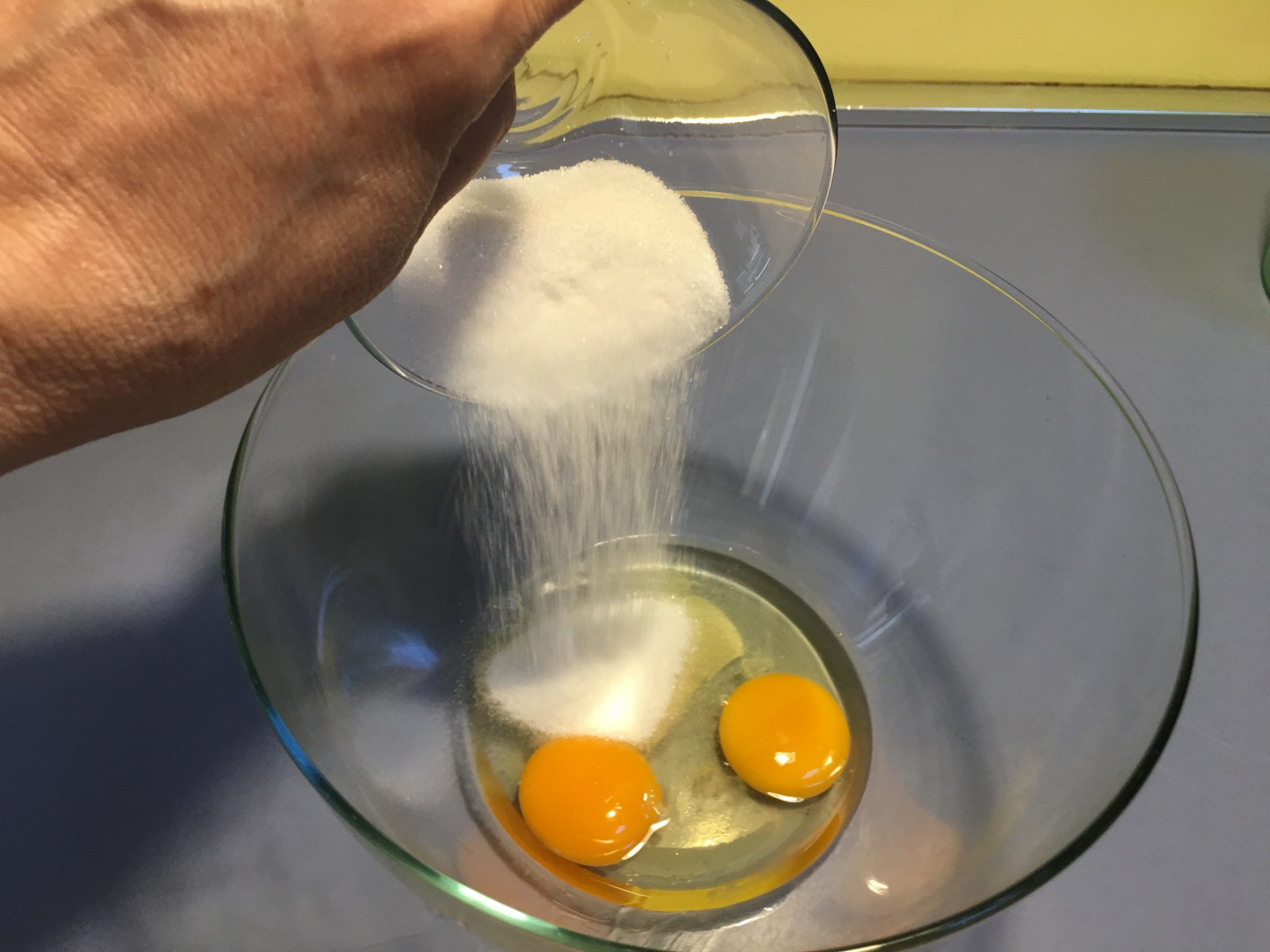 Torta invisibile giapponese - zucchero e uova in una ciotola
